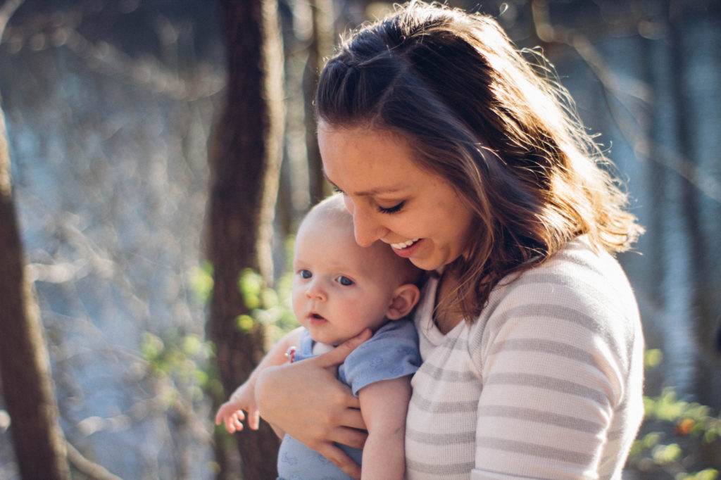 Mamma sorridente con bambino in braccio